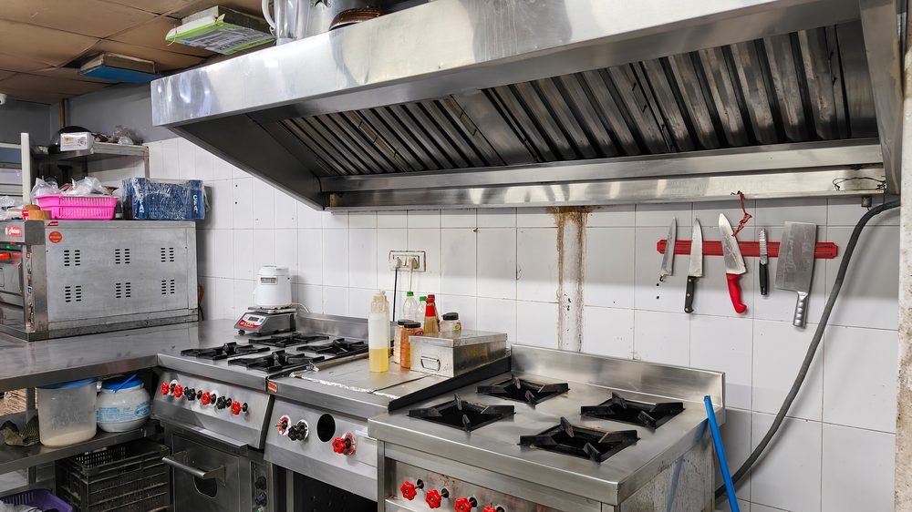 Clean commercial chimney hood over a gas range in a Blue Wings kitchen